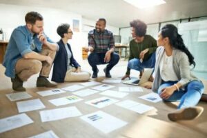 manque de communication à aisance relationnelle -travail en équipe assis sur le sol avec des feuilles