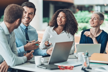 hommes et femmes au travail qui discutent autour d'un ordinateur portable